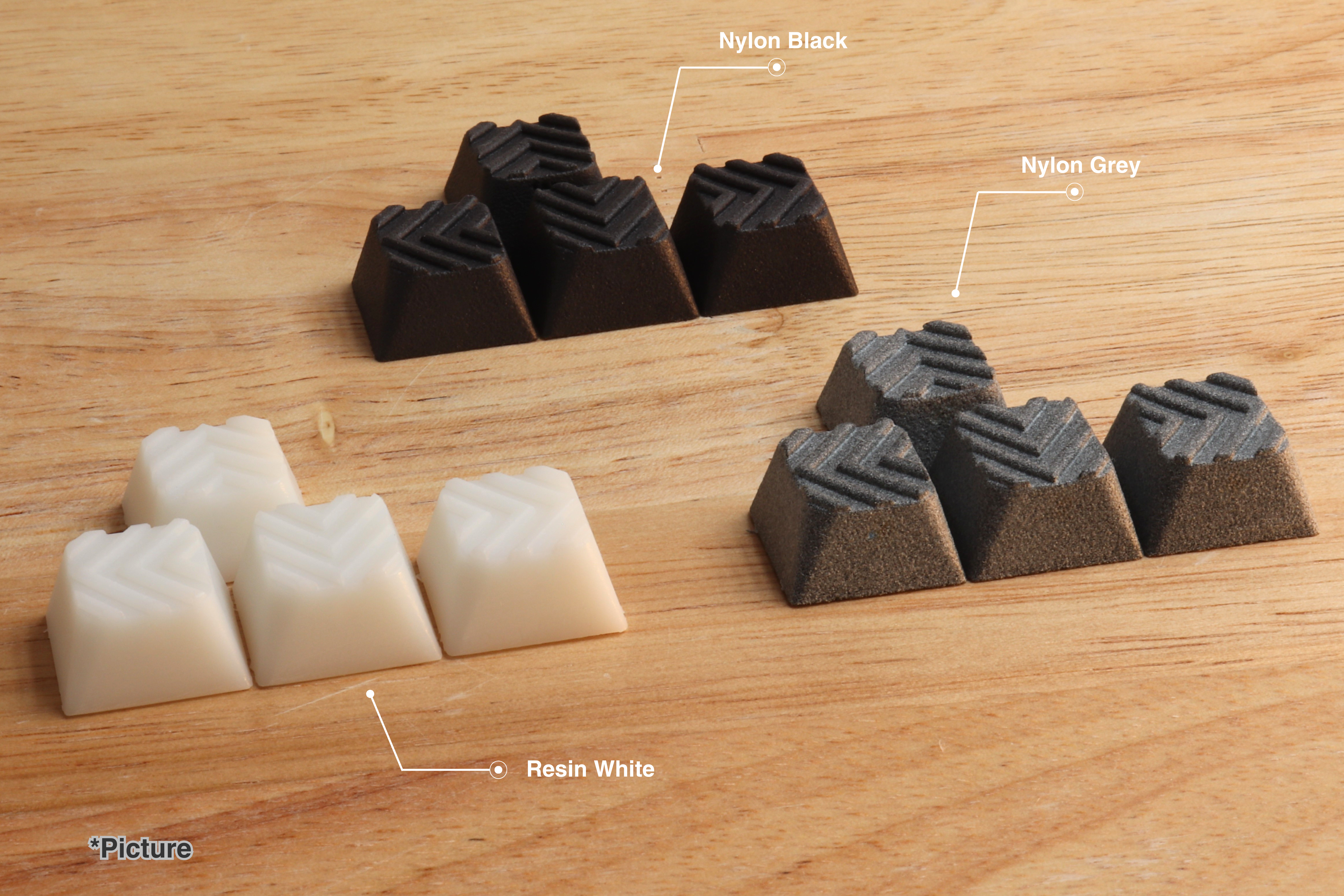 Cherry Arrow Keycap Set Shown in Resin White, Nylon Black, and Nylon Grey