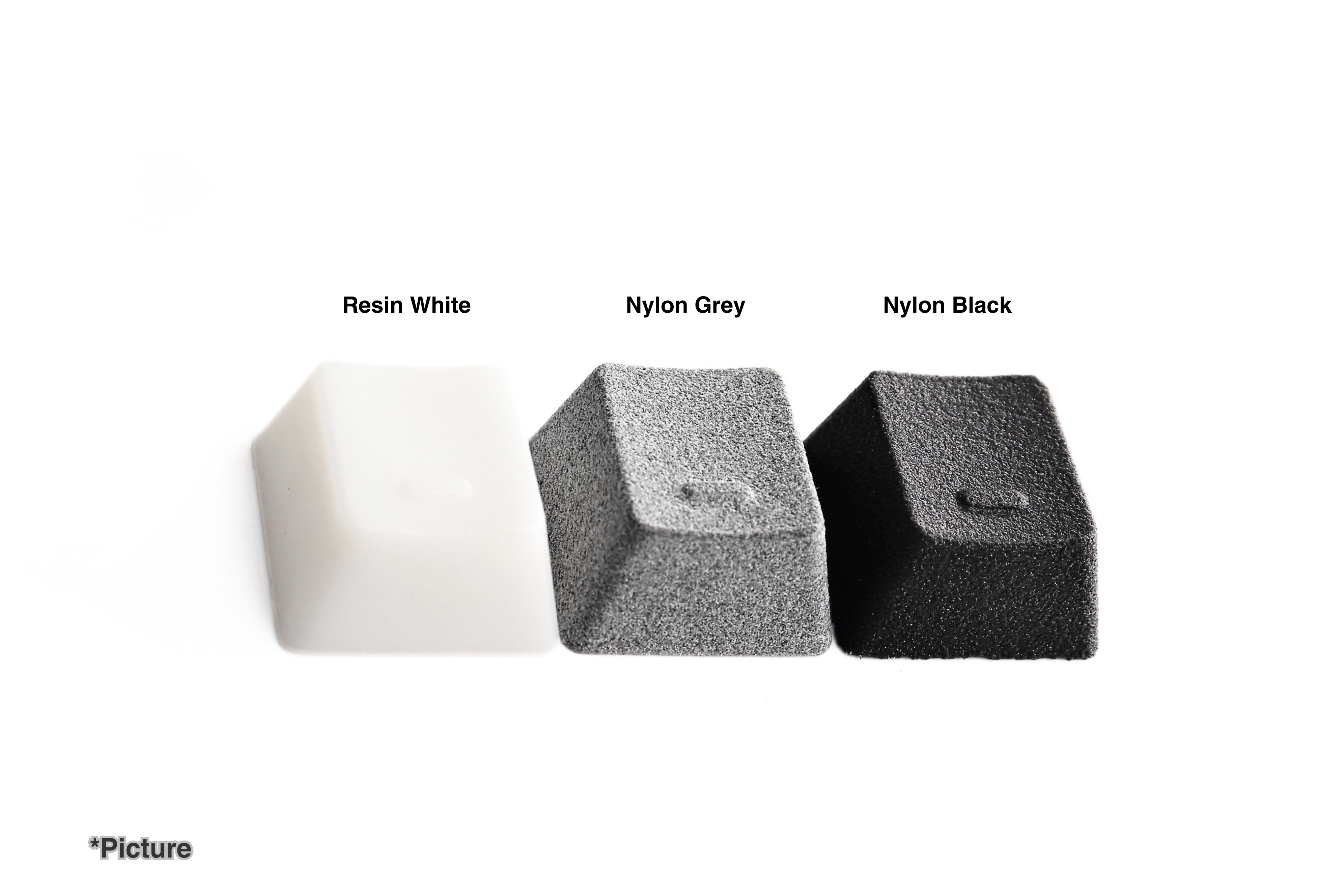 OEM Homing Keycaps Shown in Resin White, Nylon Grey, and Nylon Black